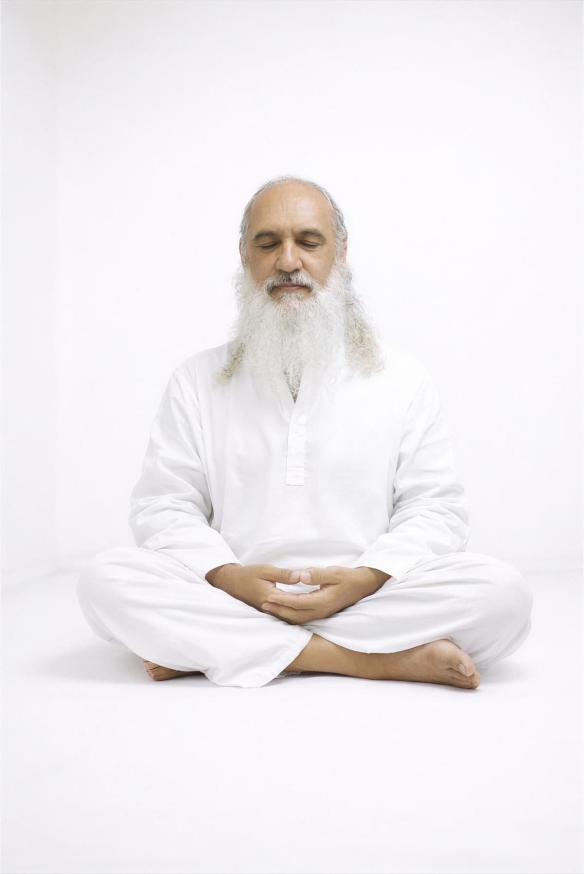 Sri Prem Baba seated in meditation in a bright white room